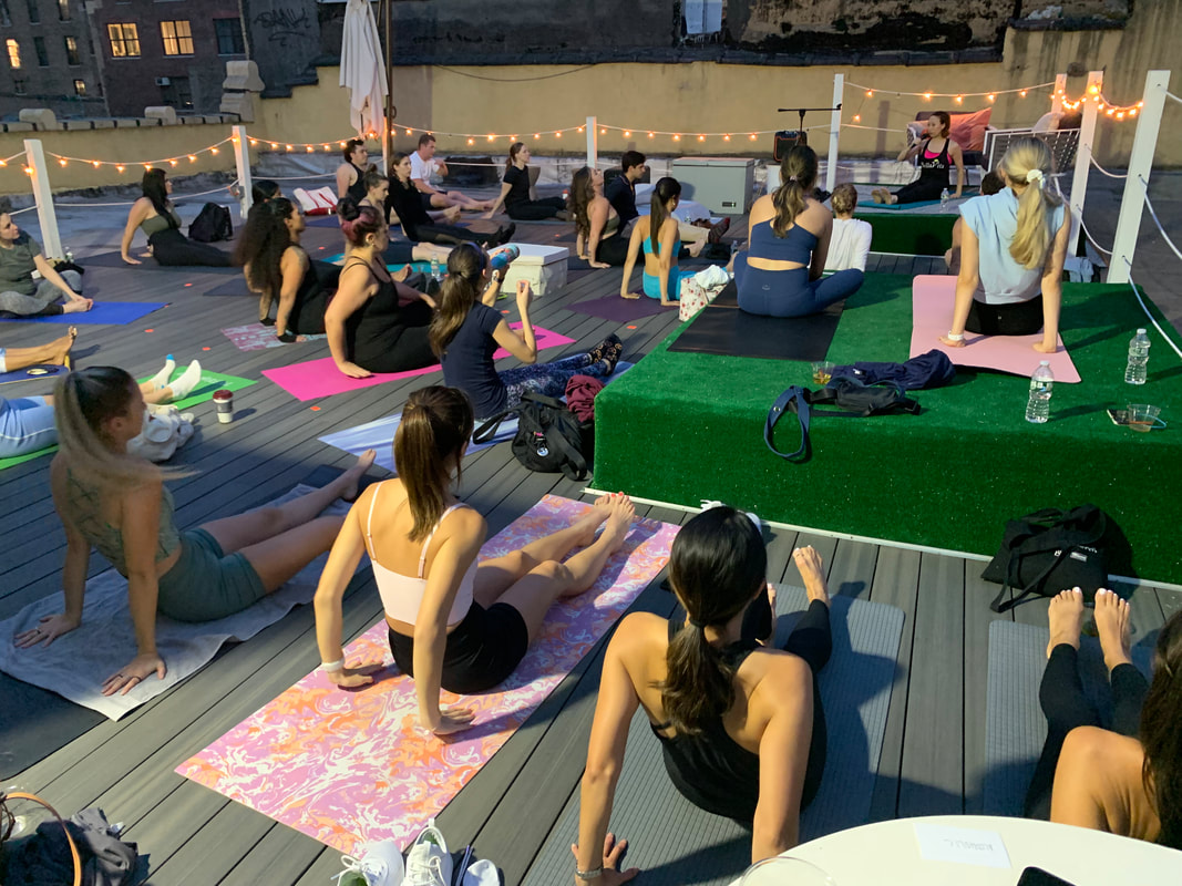 Yogis are lying down on mats on rooftop yoga event